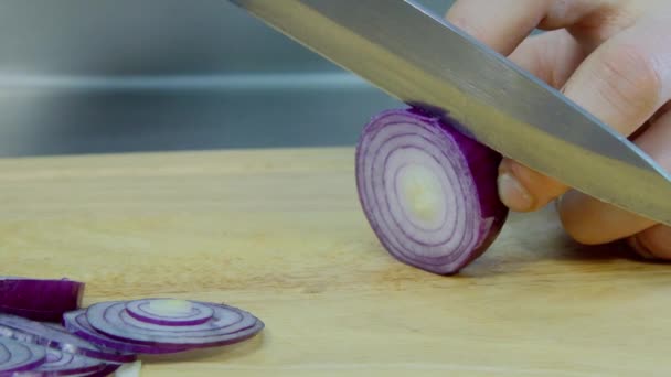 Cortar una cebolla en un soporte de madera — Vídeos de Stock