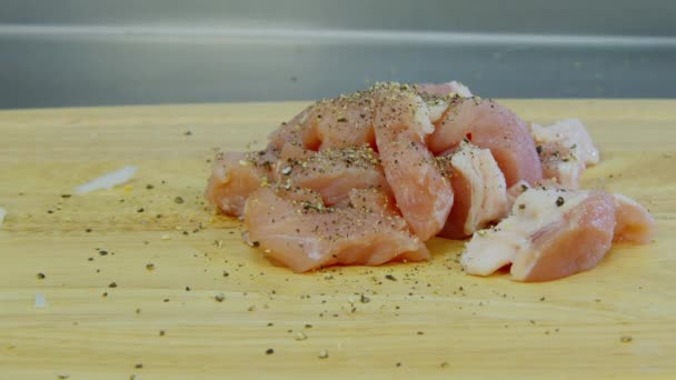 Espolvorear cerdo con sal sobre la mesa — Vídeo de stock