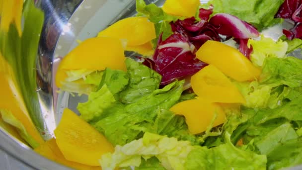 Yellow pepper falling on lettuce leaves — Stock Video