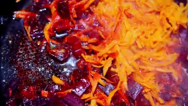 Морковь и свекла завариваются в сковороде — стоковое видео