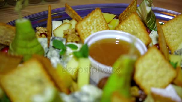 Queso, galletas y miel se encuentran en el plato — Vídeo de stock