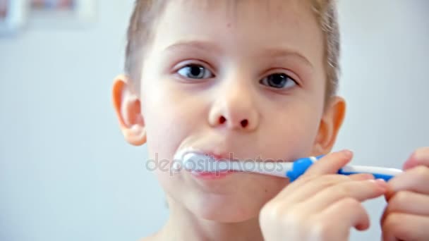 De jongen reinigt een tanden borstel — Stockvideo