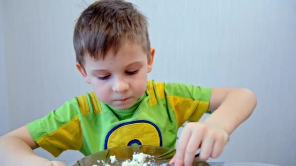 Rapaz come mingau de cereal de uma chapa — Vídeo de Stock