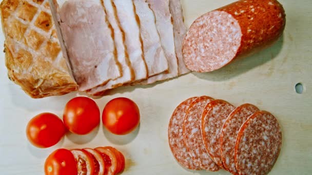 Ham, salami en tomaten worden op het bord — Stockvideo