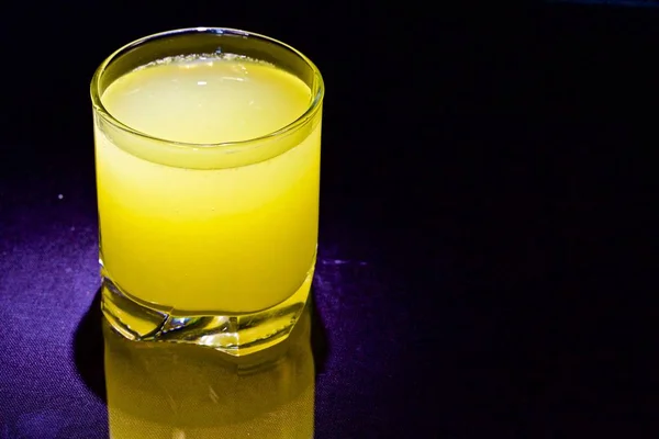 Yellow cocktail in glass on black background — Stock Photo, Image