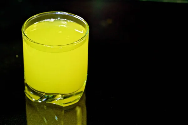Желтый коктейль в стекле на черном фоне — стоковое фото