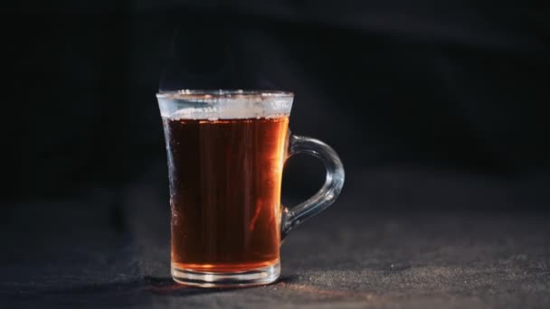 Tea in transparent Cup on a dark background. Slow motion — Stock Video