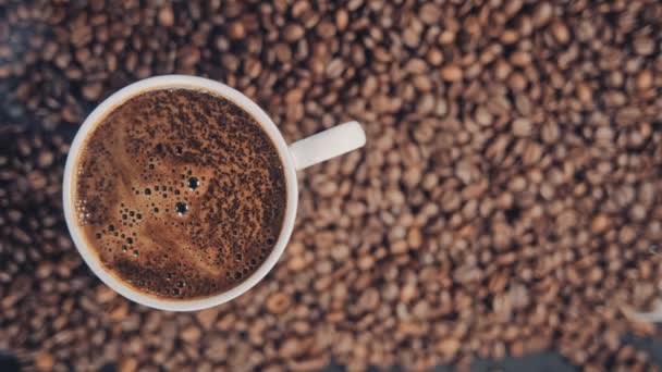 Kopp med varm dryck på rostade kaffebönor. Slow motion — Stockvideo