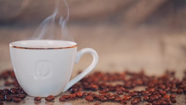 Koffiekopje op een tafel met koffiebonen. Slow motion — Stockvideo