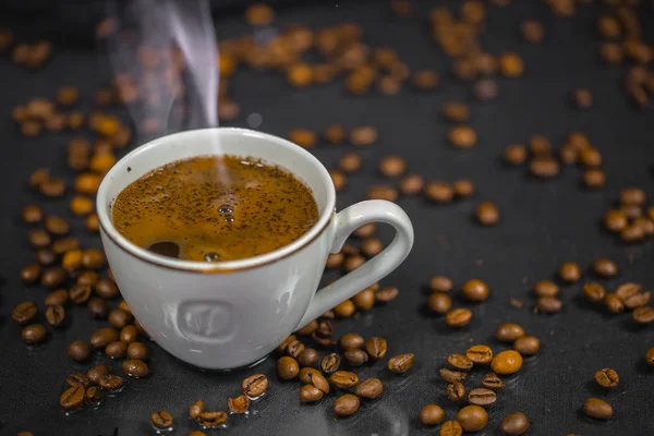 Xícara de café e grãos de café na mesa — Fotografia de Stock