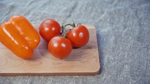 Tomates, pimentão deitado em uma tábua de madeira — Vídeo de Stock
