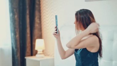 güzel kız makyaj yapıyor yatak odasında. Ağır çekim