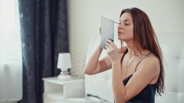 güzel kız makyaj yapıyor yatak odasında. Ağır çekim