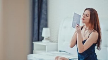 güzel kız makyaj yapıyor yatak odasında. Ağır çekim