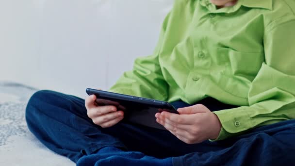 Um rapaz joga no tablet. Movimento lento — Vídeo de Stock