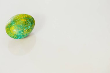 Beyaz arkaplanda yeşil Paskalya yumurtası.