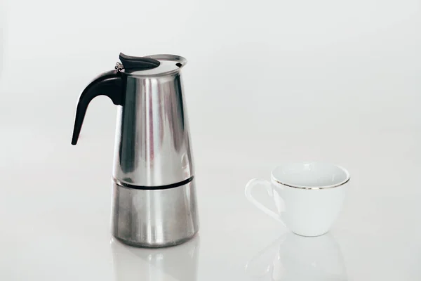 Caffettiera geyser e una tazza di caffè bianco isolato su bianco Immagini Stock Royalty Free