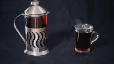 Fransız basın çay ve şeffaf bir fincan çay siyah bir arka plan ile