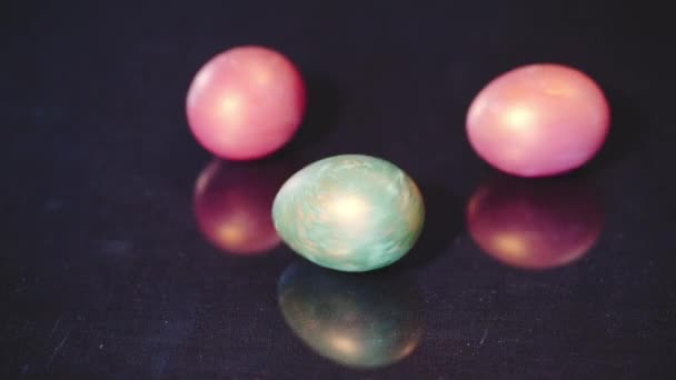 Красные и зеленые пасхальные яйца вращаются на черном фоне, замедленная съемка — стоковое видео