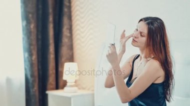 güzel kız makyaj yapıyor yatak odasında. Ağır çekim