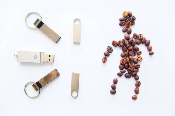 Beyaz bir arka plan üzerinde insan şeklinde USB stick ve kahve fasulye