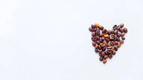 Coração de grãos de café no fundo branco — Fotografia de Stock