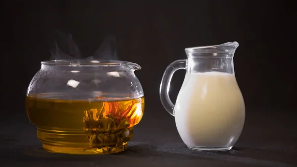 China grün blühende Teeknospe in einer Glas-Teekanne. Milch in einem kleinen — Stockfoto