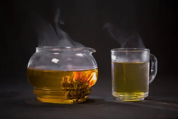 Çin yeşil çay Bud bir cam çaydanlık çiçek açar. Bir fincan çay