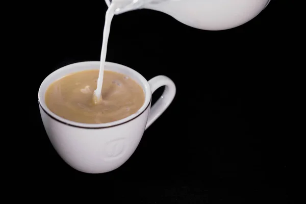 Γάλα χύνεται σε ένα φλιτζάνι του καφέ — Φωτογραφία Αρχείου