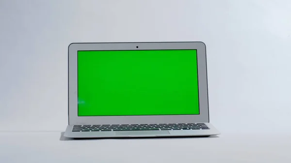 Laptop på vit bakgrund, grön skärm Stockbild