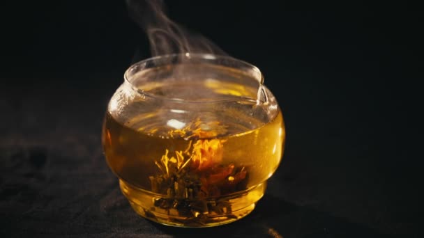 Цветки зеленого китайского чая цветут в стеклянном чайнике — стоковое видео