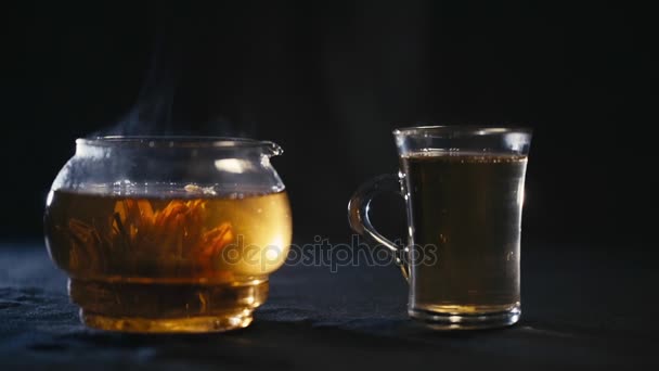 Kínai zöld tea Bud virágzik egy üveg teáskanna. Egy csésze tea — Stock videók