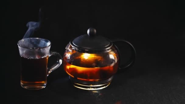 černý čaj v průhledné konvice čaj ve skle Cup na černém pozadí