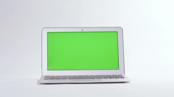 Ноутбук на білому фоні, зелений екран — стокове відео
