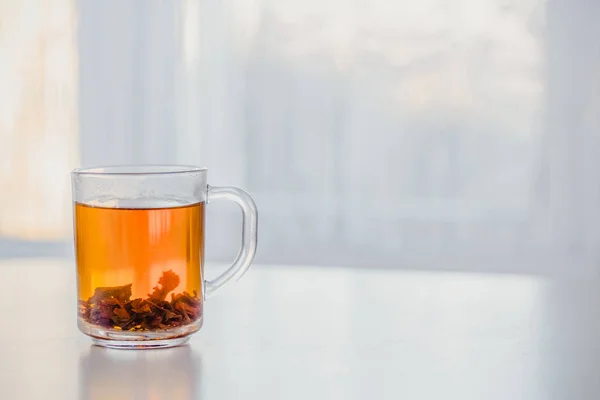 Стакан горячего чая на столе у окна — стоковое фото