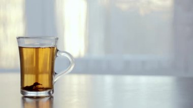 bir fincan sıcak çay cama masada buğulaması.