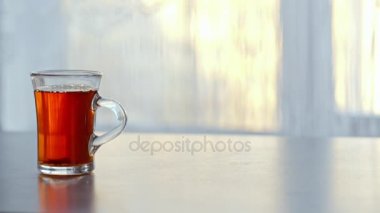 bir fincan sıcak çay cama masada buğulaması.