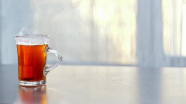 bir fincan sıcak çay cama masada buğulaması.