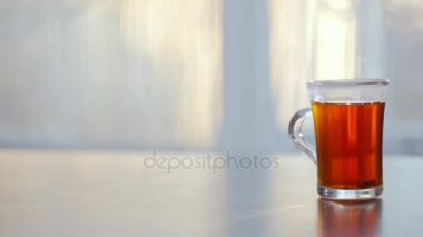 bir fincan sıcak çay cama masada buğulaması.