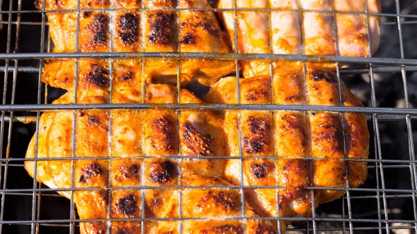 O frango é frito na grelha na grelha — Fotografia de Stock