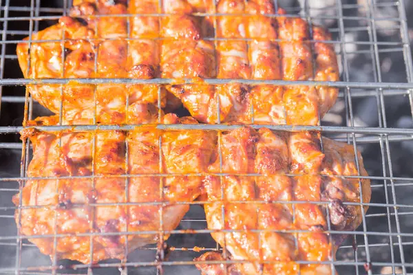 Das Huhn wird auf dem Grillrost auf dem Grill gebraten — Stockfoto