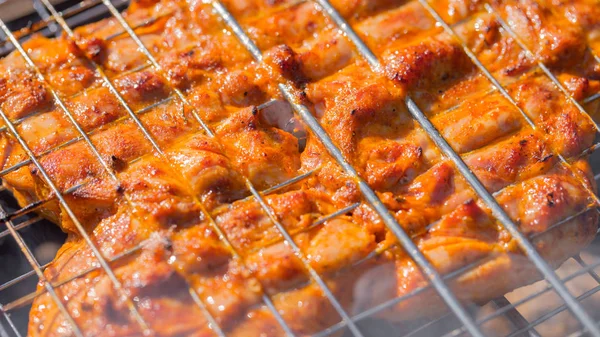 Das Huhn wird auf dem Grillrost auf dem Grill gebraten — Stockfoto