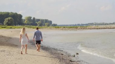 bir adam ve bir kız sahilde yürüyor