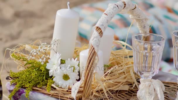 Корзина для пикника, бокалы, цветы и свечи — стоковое видео