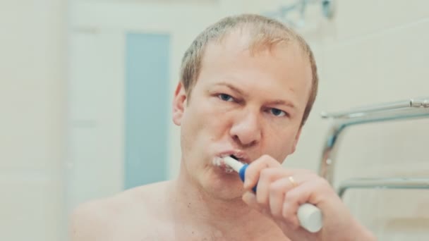 Мужчина в ванной чистит ей зубы. Медленное движение — стоковое видео
