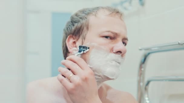 Um homem faz a barba na casa de banho. Movimento lento — Vídeo de Stock