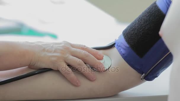 Врач измеряет артериальное давление человеку крупным планом — стоковое видео