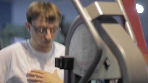 Knappe sportieve man is de uitoefening van in gym centrum — Stockvideo