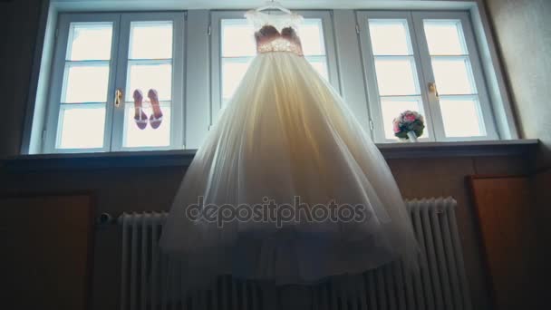 Vestido de noiva pendurado na janela — Vídeo de Stock