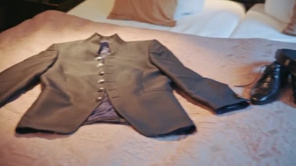 Мужской пиджак лежит на кровати — стоковое видео